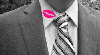 uomo in giacca e cravatta con bacio di rossetto